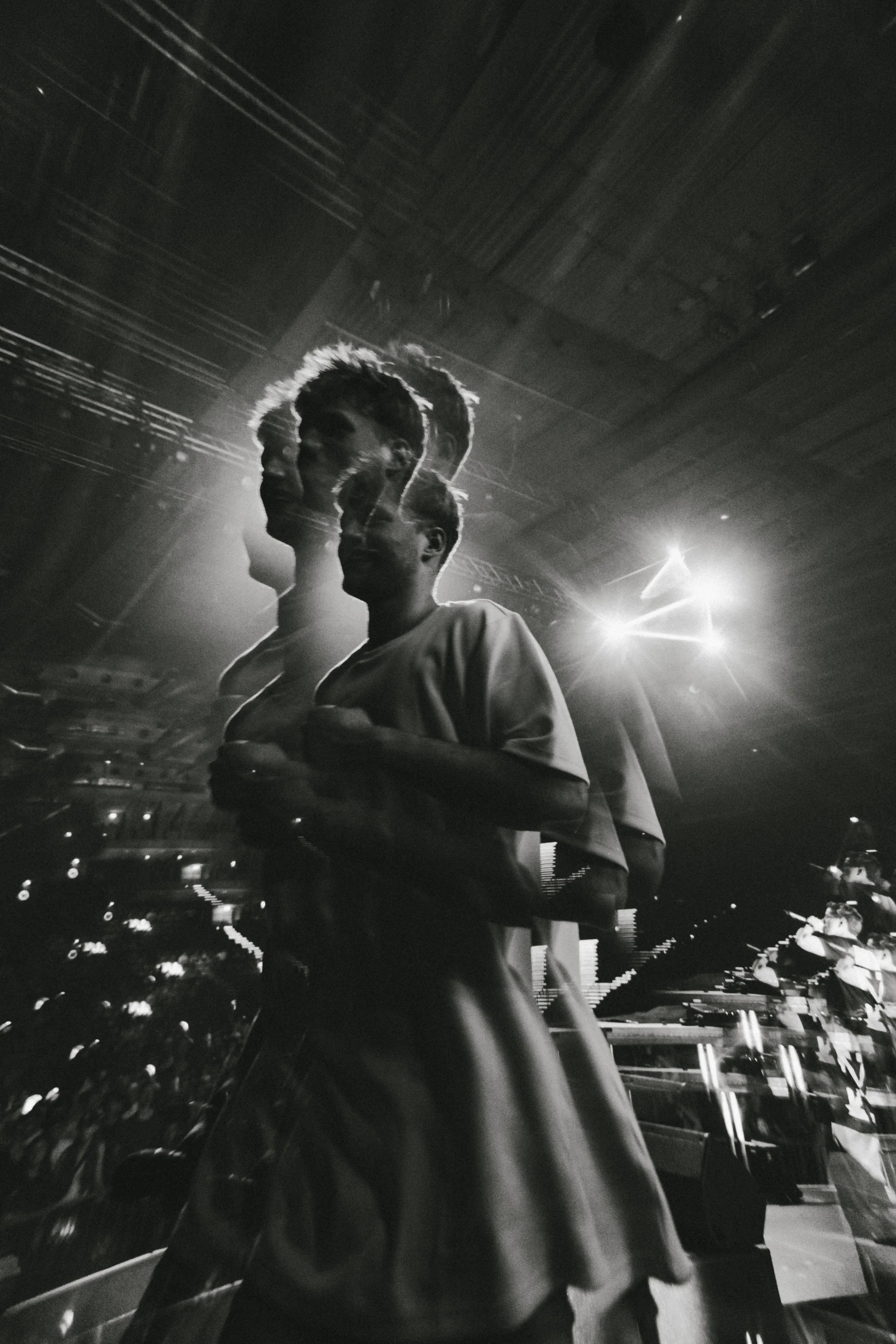 Black and white photo of Lukas Goss on stage in front of an arena crowd